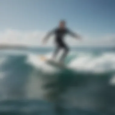 An aerial view of a surfer riding a non-electric hydrofoil surfboard on calm waters