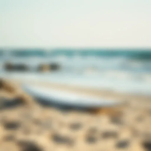 A sleek foil surfboard resting on a sandy beach under a clear sky