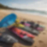 A variety of used kitesurfing equipment displayed on a beach