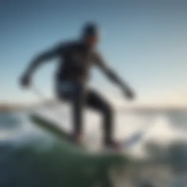 A kiteboarder in action wearing a cold water wetsuit against a backdrop of ocean waves.